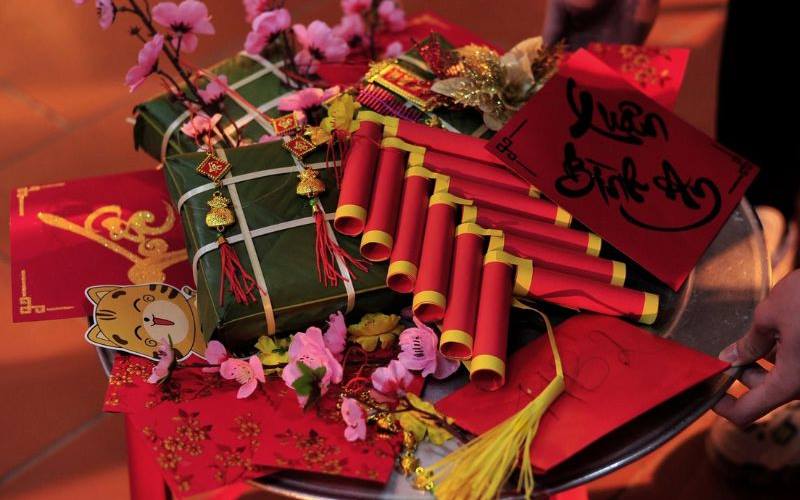 Bao lì xì đỏ trên mẹt bánh chưng tượng trưng cho may mắn và tài lộc đầu năm.