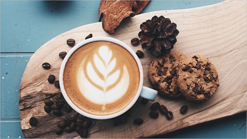 Latte art đẹp mắt cùng bánh quy và hạt cà phê
