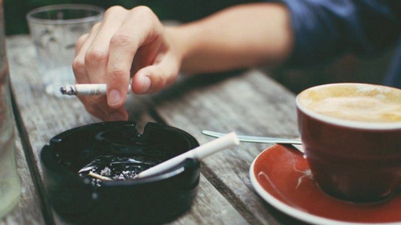 Tách cà phê cappuccino thơm ngon cùng điếu thuốc thư giãn