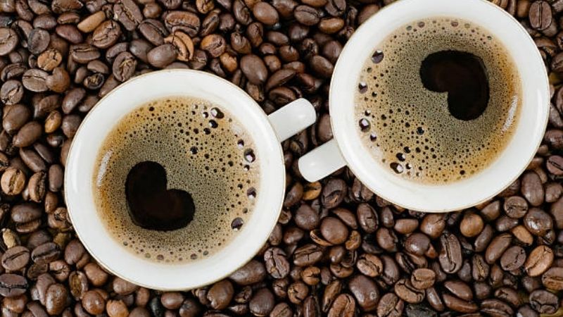 Đôi ly cà phê tình yêu đen trái tim giữa hạt rang