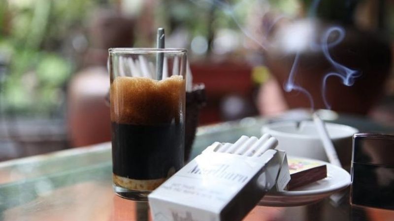 Cafe sữa phân tầng cùng điếu thuốc đang cháy