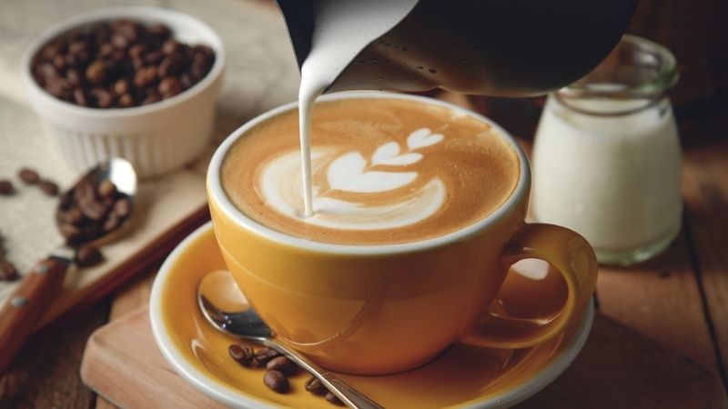 Barista đang tạo hình latte art đẹp mắt cho khách hàng