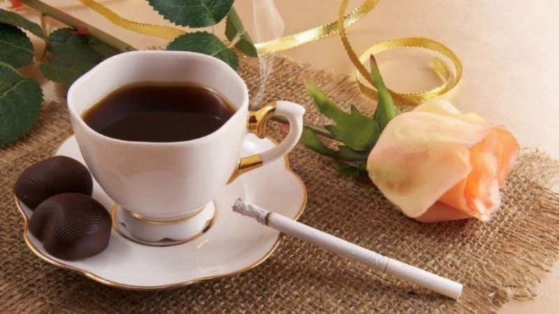 Tách cafe đen cùng hoa hồng nhạt trên khăn thô