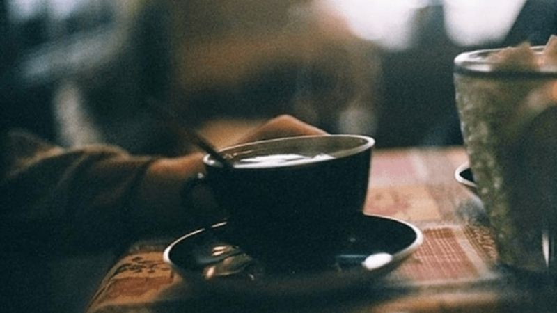 Tách cafe tối màu trong quán mờ ảo