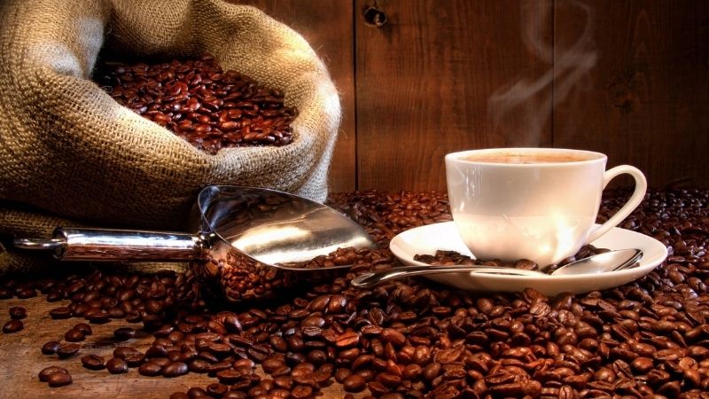 Cà phê rang tươi cùng tách espresso nóng hổi thơm lừng