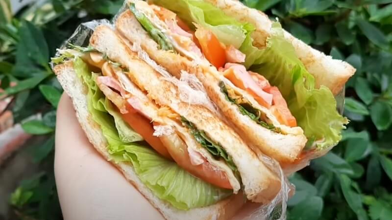 Thưởng thức bánh mì sandwich kẹp trứng xúc xích