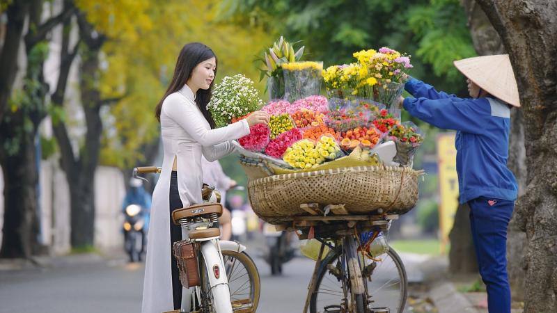 Hình ảnh thiếu nữ lựa hoa trên vỉa hè