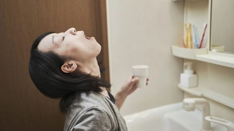 Súc miệng bằng nước muối ấm Súc miệng bằng nước muối ấm