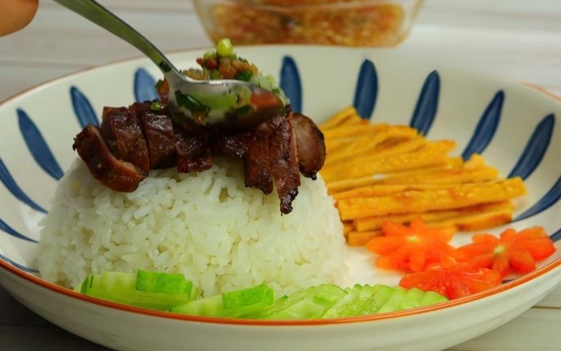 Món cơm thịt heo hoàn chỉnh có cơm mềm, thịt nướng vàng, thịt băm đậm vị và trứng chiên thơm ngon