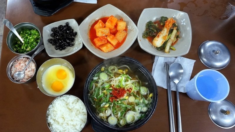 Ăn khi còn nóng, trộn cơm với nước dùng, thêm hành lá, hạt mè và kimchi tùy thích