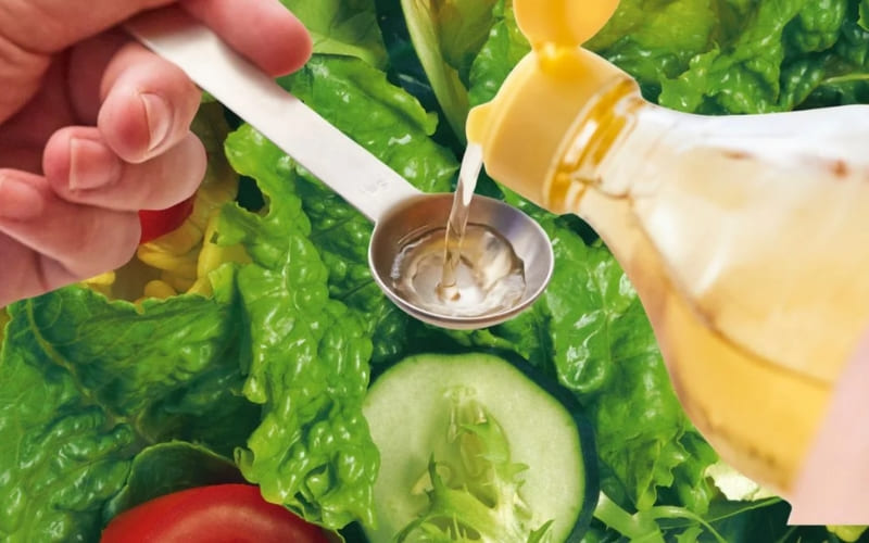 Người nấu dùng dầu mè trộn salad hoặc xào món ăn. Người nấu dùng dầu mè trộn salad hoặc xào món ăn.