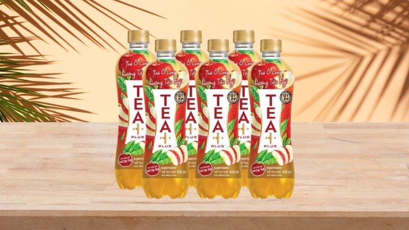 Chai nhựa vàng nâu thon gọn, nhãn nổi bật với màu đỏ táo và xanh lá trà