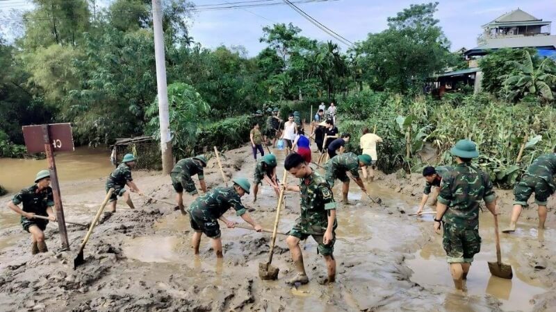 Bộ đội cùng dân khắc phục hư hỏng cầu đường.