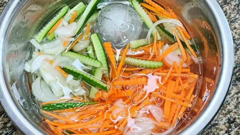 Ngâm cà rốt, hành tây và dưa leo vào nước đá