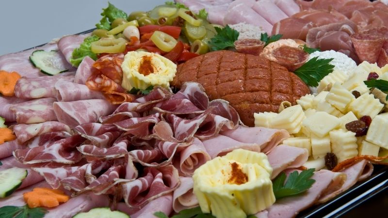 Sử dụng khay gỗ bày đồ nguội theo hình vòng cung, trang trí thêm lá thơm và các loại hạt