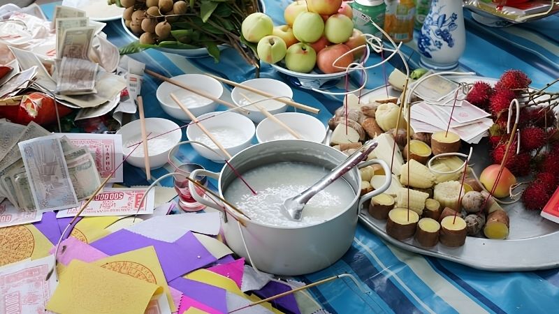 Mâm cúng gồm muối, gạo, cháo loãng, trái cây, bánh kẹo, mía, nước và tiền vàng