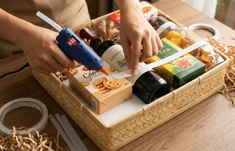 Cố định sản phẩm bằng keo hoặc băng dính giúp giỏ quà vững vàng, không xô lệch khi di chuyển