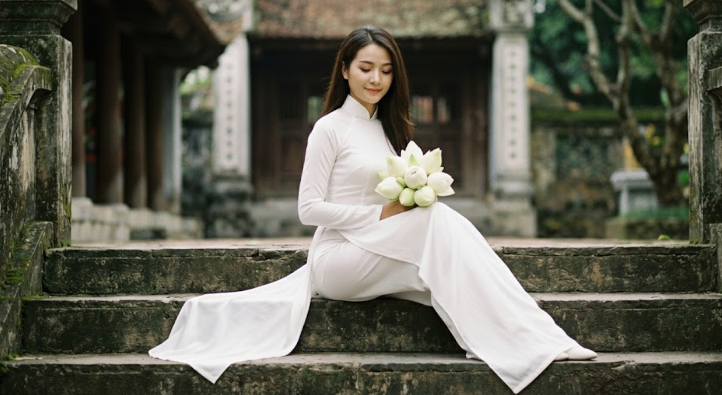 Cô gái mặc áo dài, ngồi trên bậc thêm