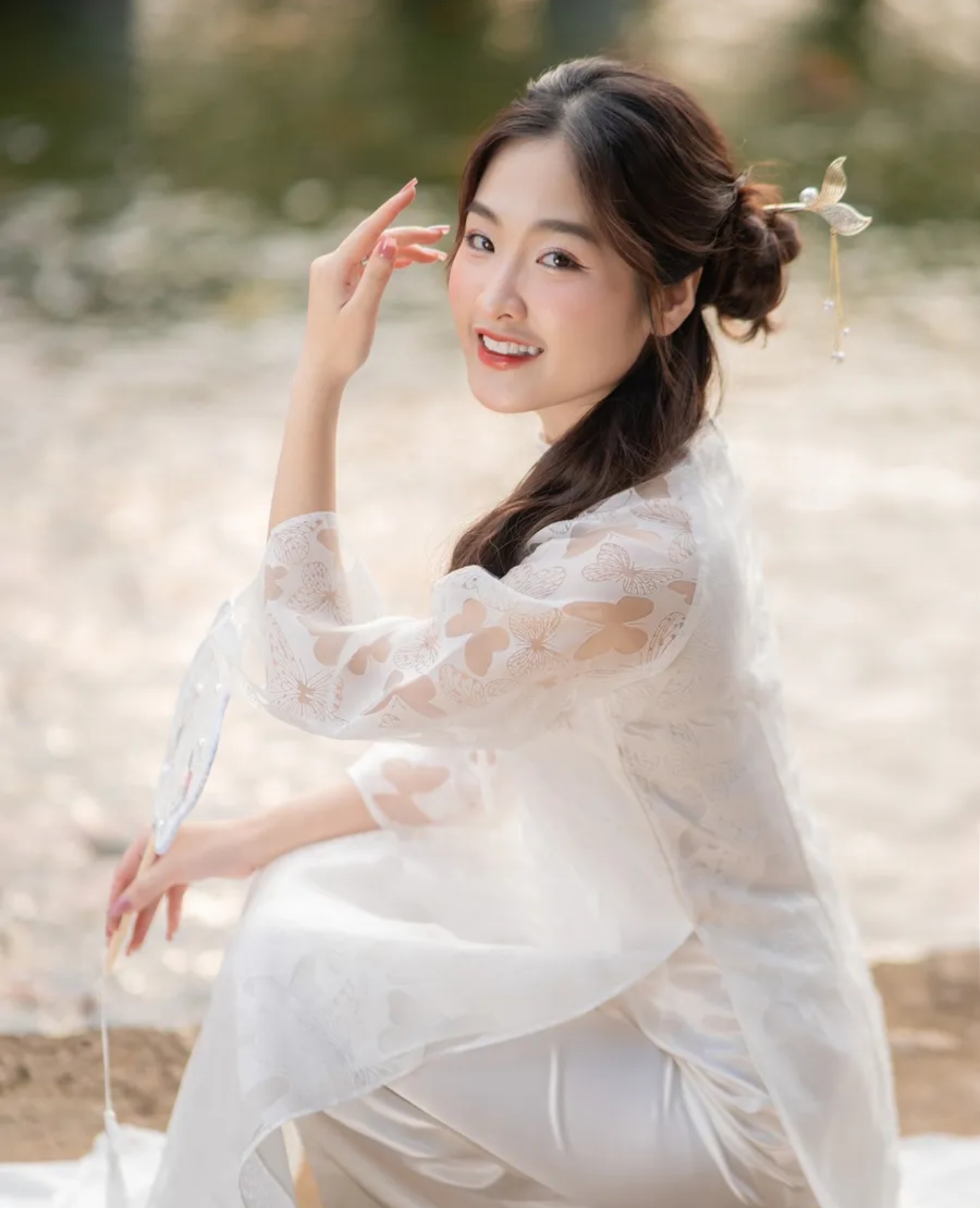 Đặt tay thoải mái tự nhiên để có bức ảnh tạo dáng với áo dài mượt mà, lả lướt