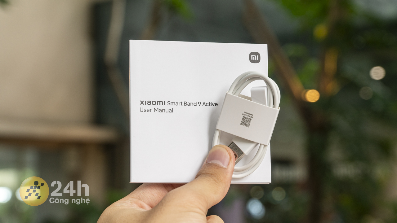 Bên trong hộp đựng Xiaomi Smart Band 9 Active chứa dây sạc nam châm và sách hướng dẫn sử dụng.