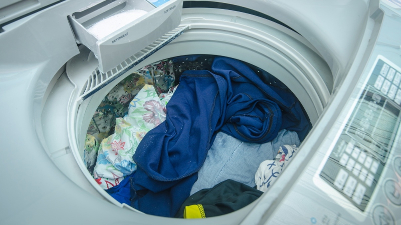 Mở nắp, dàn đều quần áo trong lồng giặt, tránh dồn lệch sang một bên gây mất cân bằng khi vắt