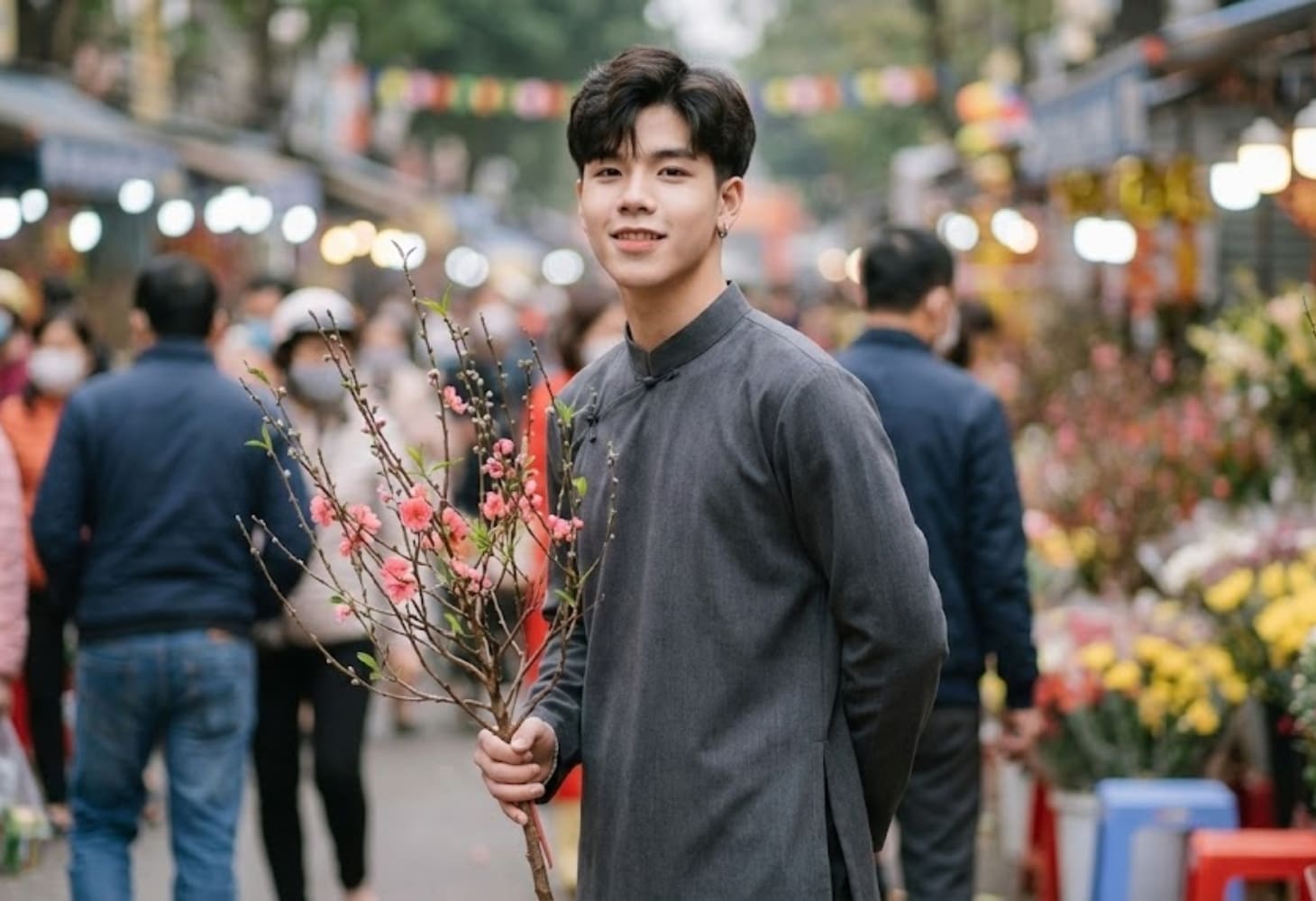 Chàng trai chụp ảnh với cành đào trong chợ xuân