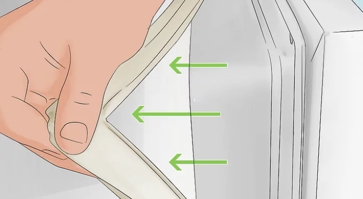 Kéo miếng gioăng cũ trượt khỏi lớp lót nhựa trên cửa tủ lạnh