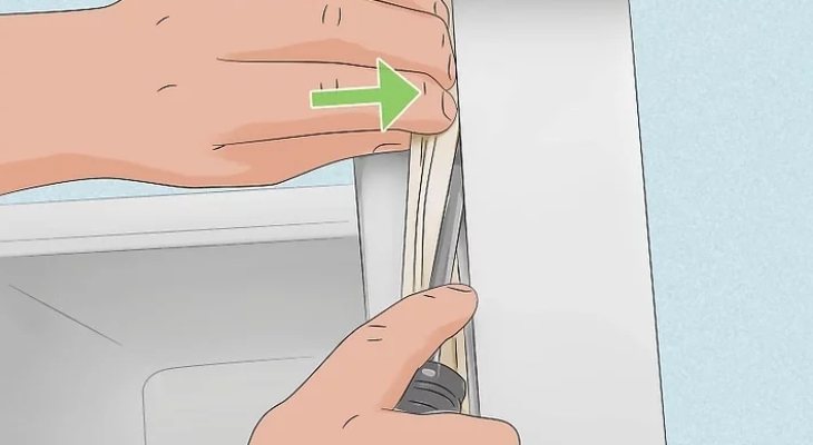 Dùng tua vít đầu dẹt đẩy miếng gioăng mới vào rãnh trên cửa tủ lãnh